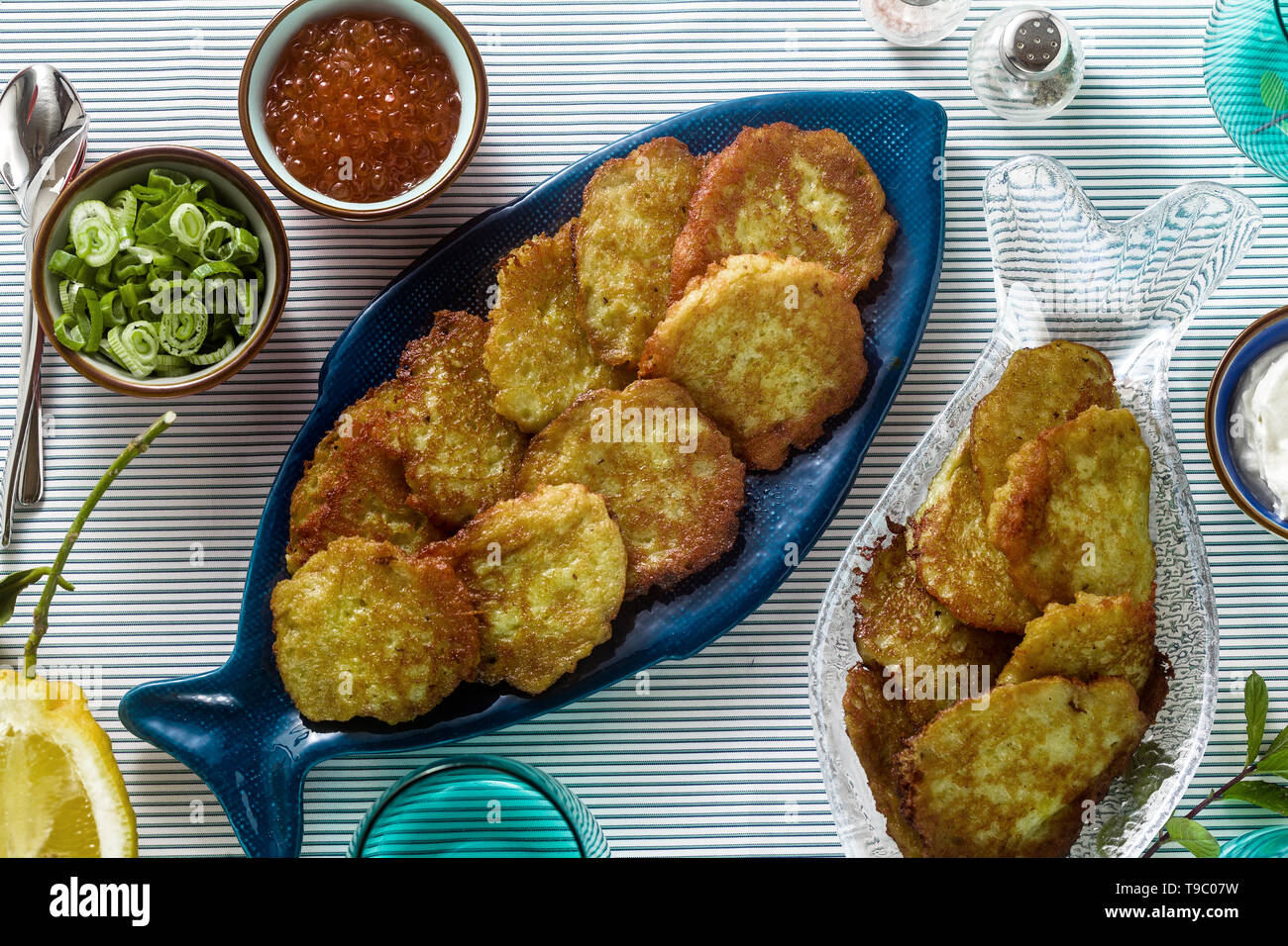 fish patties served on the table with red caviar, green onions and sour cream. fish homemade dish Stock Photo