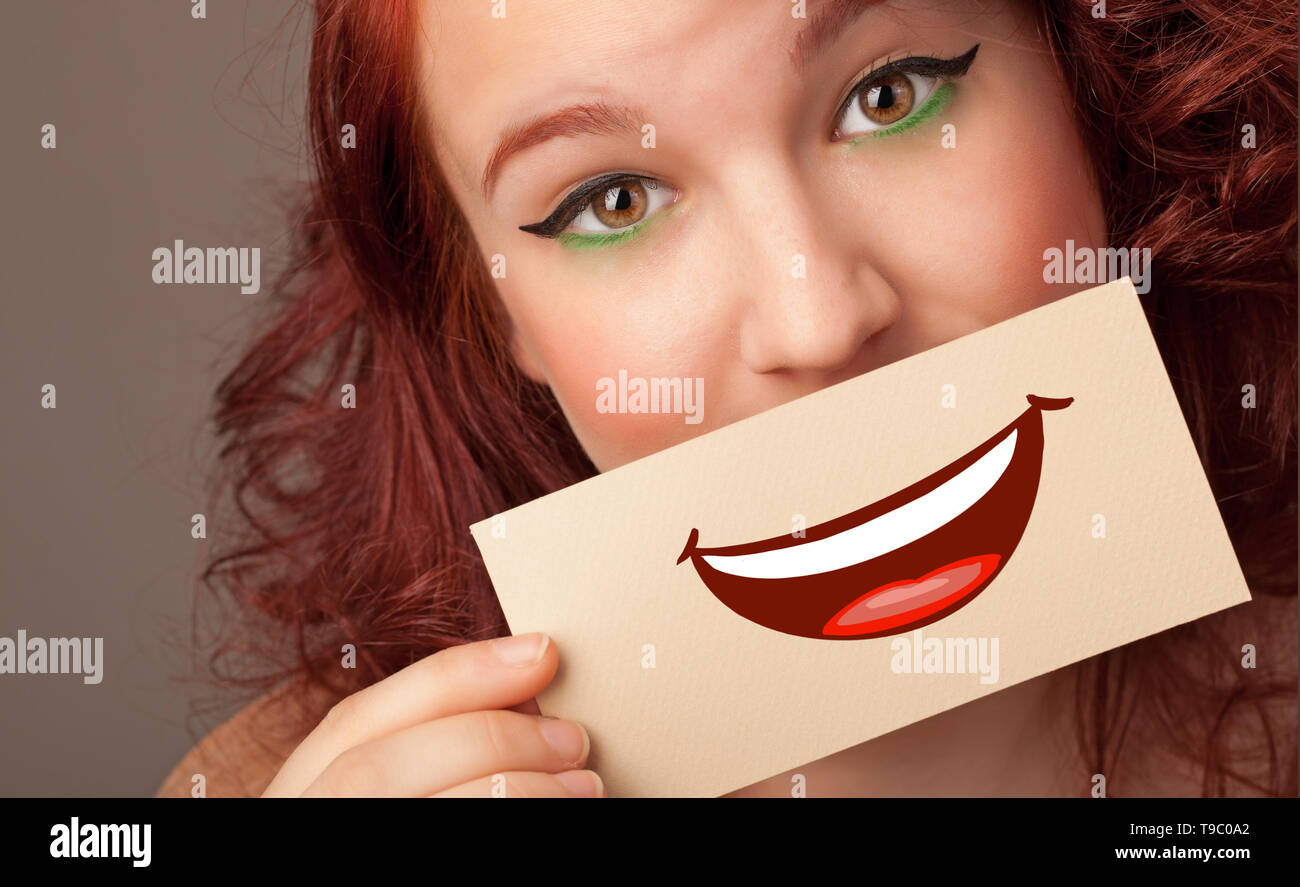 Person holding card in front of his mouth with ironic smile  Stock Photo
