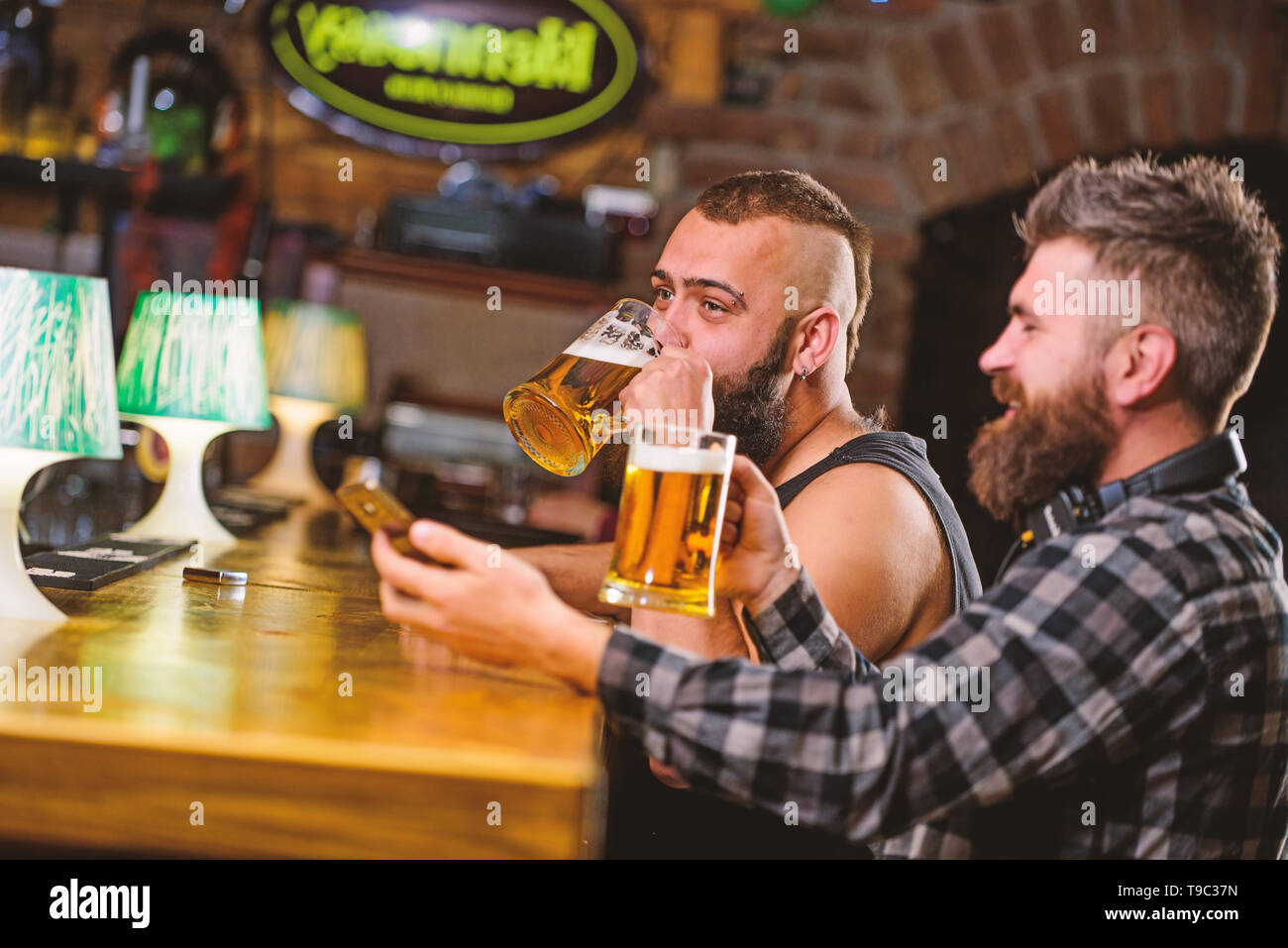 Men drinking beer together. Hipster brutal man drinking beer with
