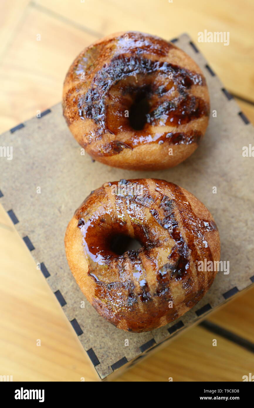 Two chocolate donuts on a wooden background Stock Photo
