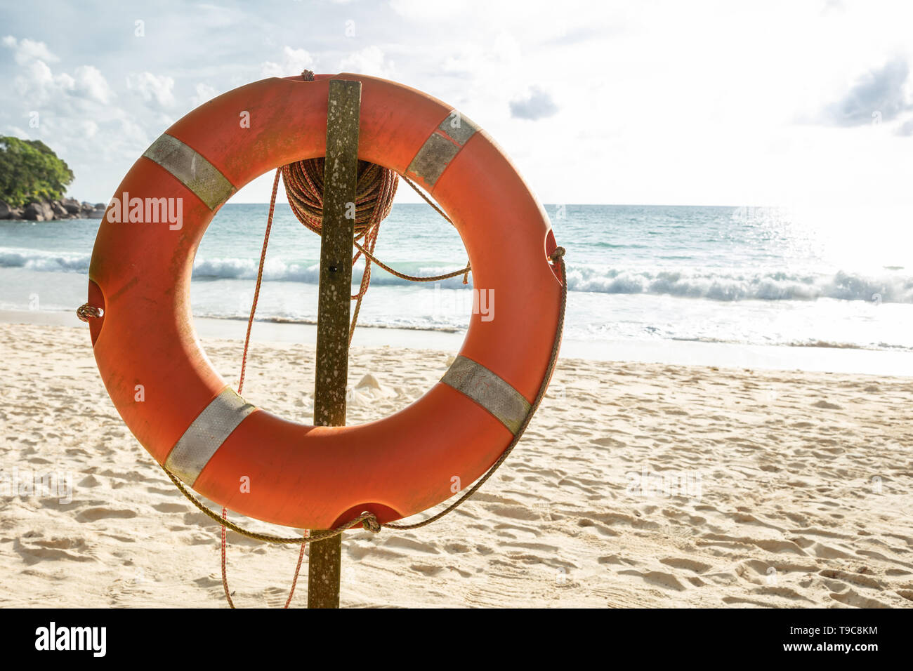 Close-up Of An Orange Lifebuoy In Front Of Sea At Beach Stock Photo