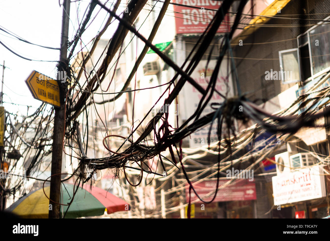 Tangled messy electrical wires on pole posing a safety hazard Stock