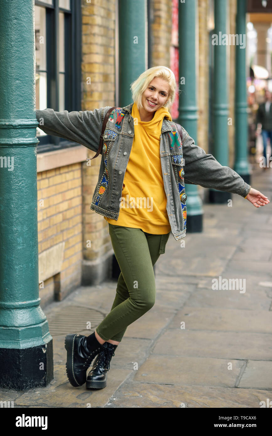 Young woman arms raised enjoying in urban background Stock Photo - Alamy