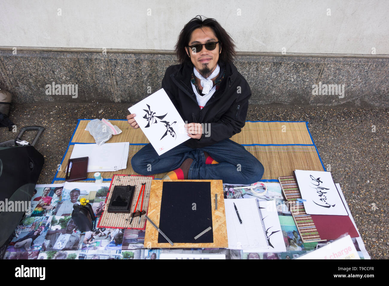 A Japanese calligrapher at work on London's Southbank - Your Name in Japanese Stock Photo