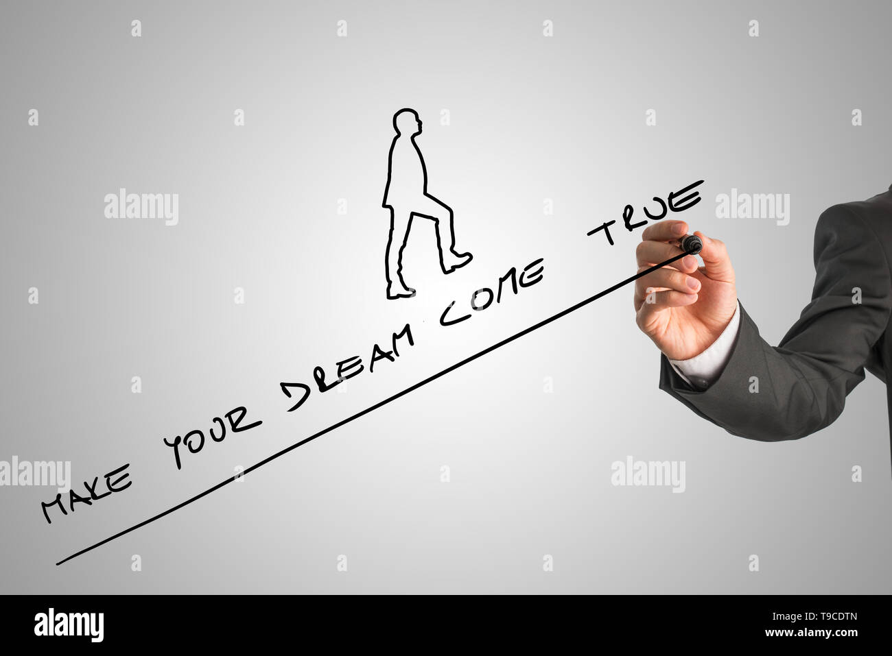 Writing Upwards Hand of businessperson writing make your dream come true along upward ...