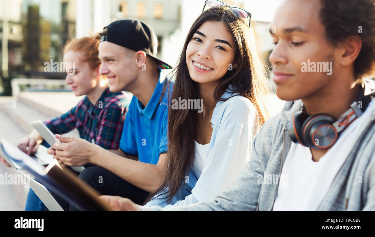 Cute Diverse Teen Students Studying Together Outdoors Stock Photo
