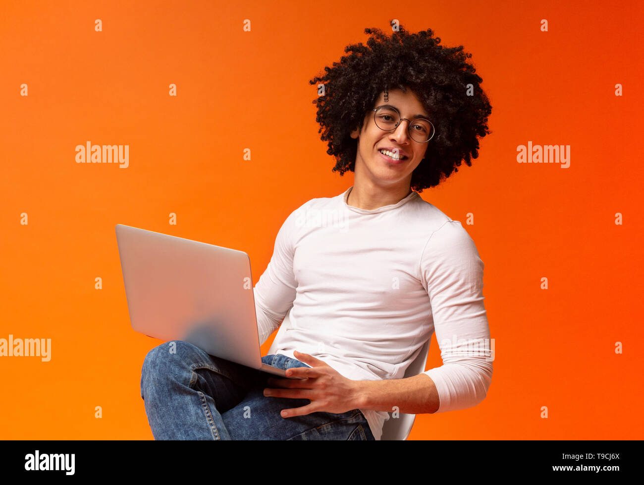 Cheerful african american guy watching webinar on laptop Stock Photo