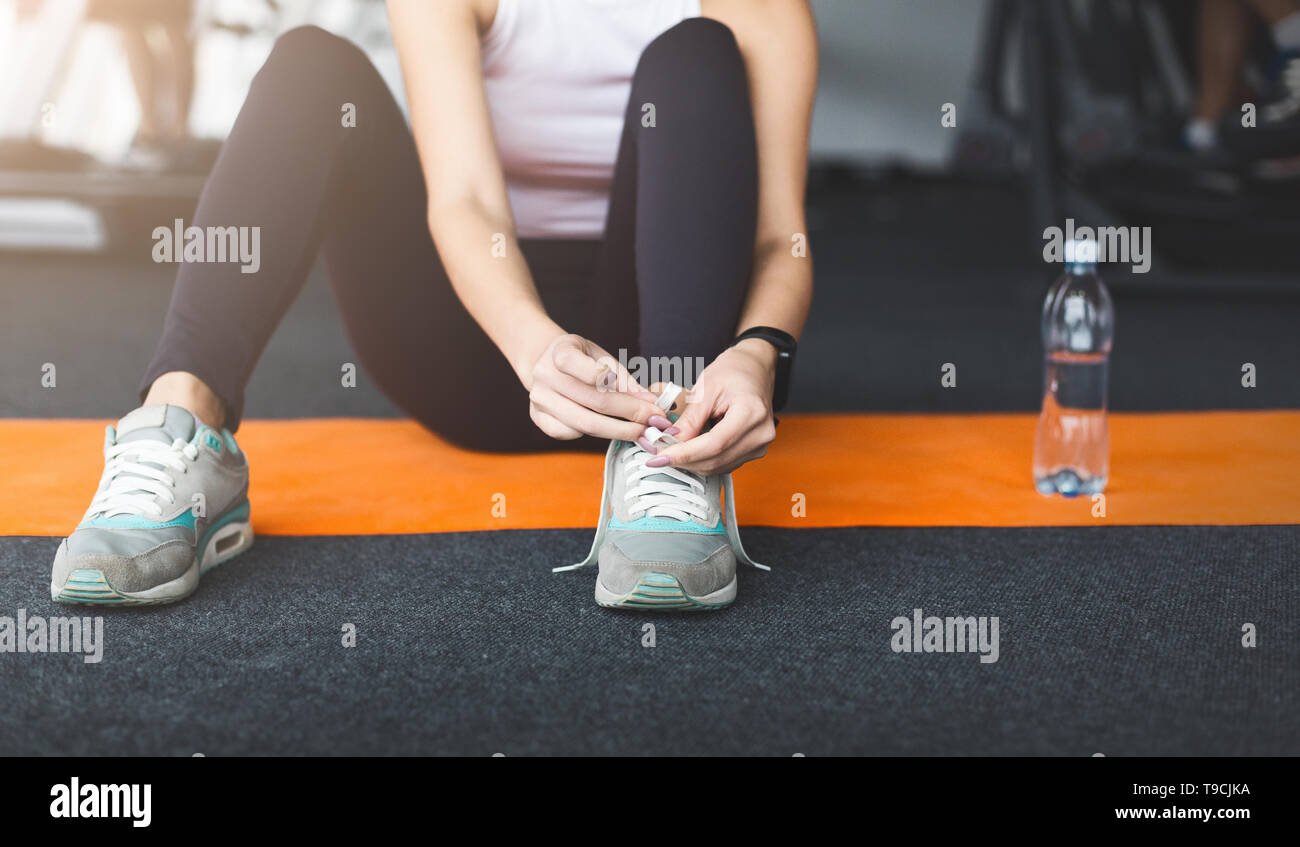 Ready for training. Woman tying laces preparing for workout Stock Photo