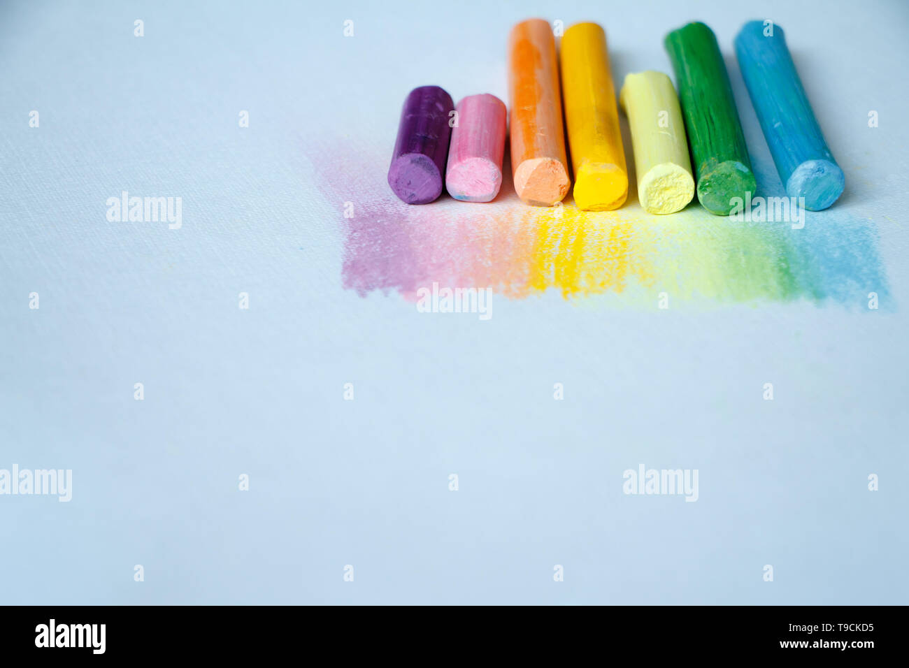 Close up view of the colorful chalk pastels on the white background, soft focus Stock Photo