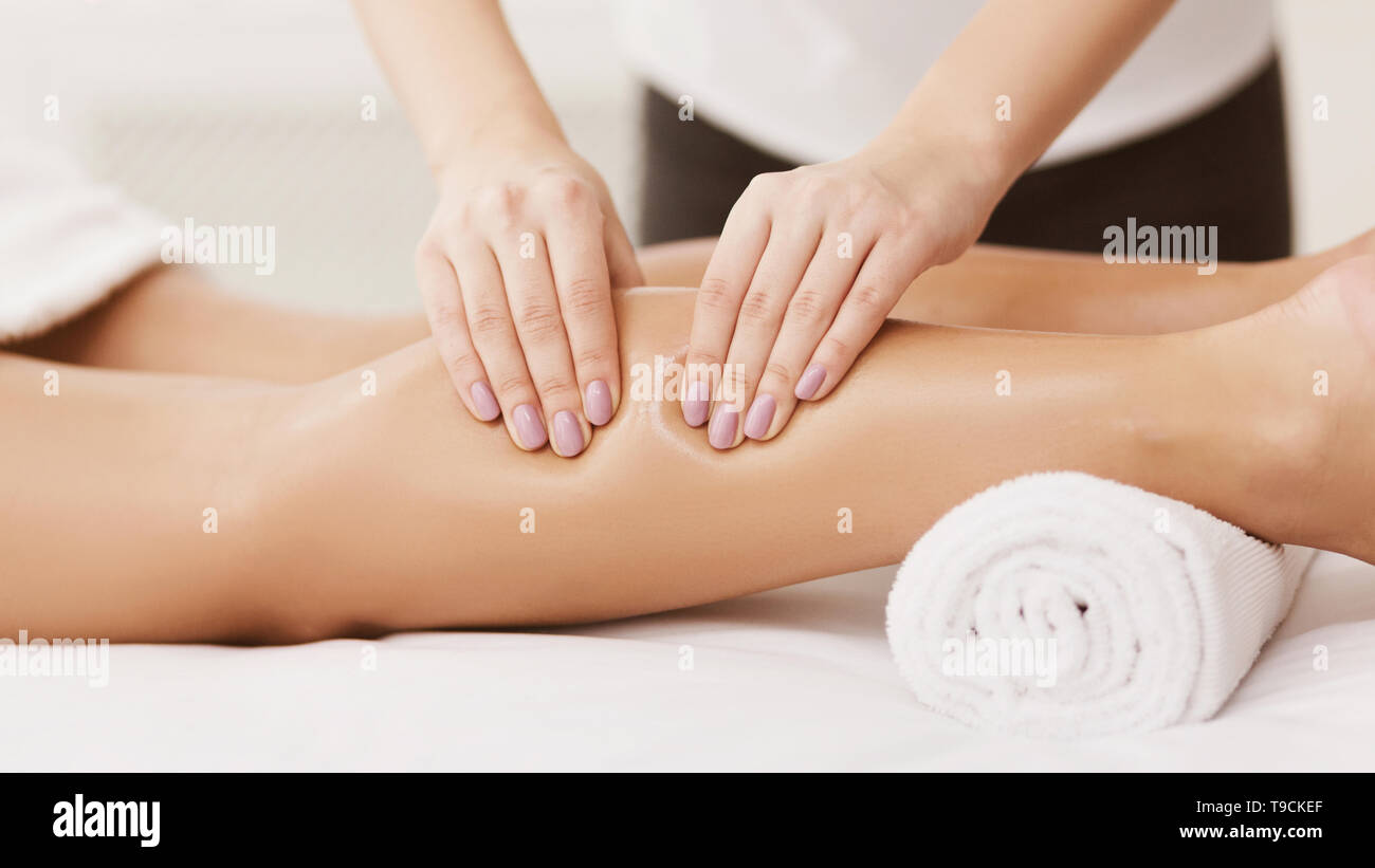 Sports Massage. Therapist Massaging Woman Calves, Closeup Stock Photo