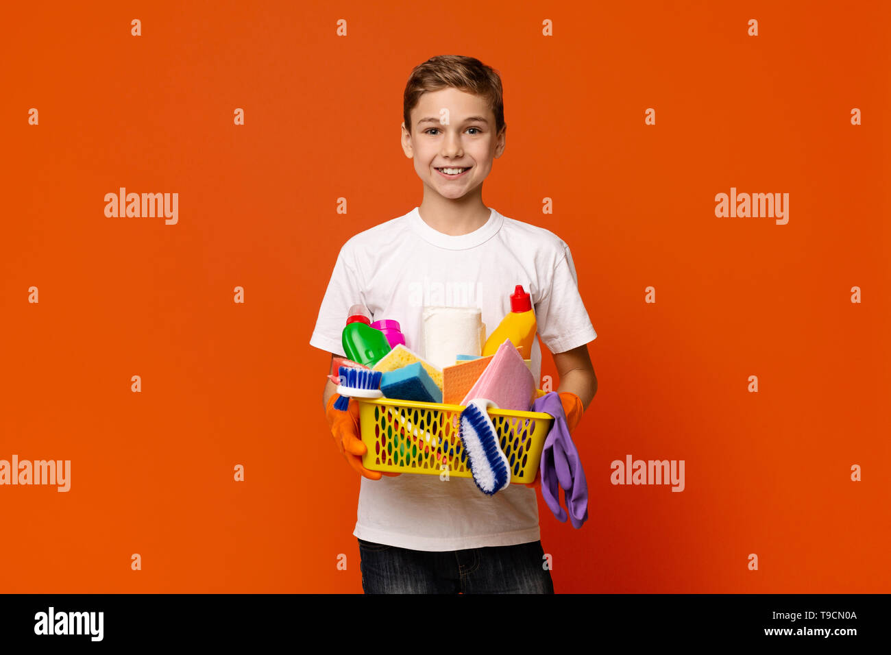 Cute boy holding set of cleaning supplies Stock Photo