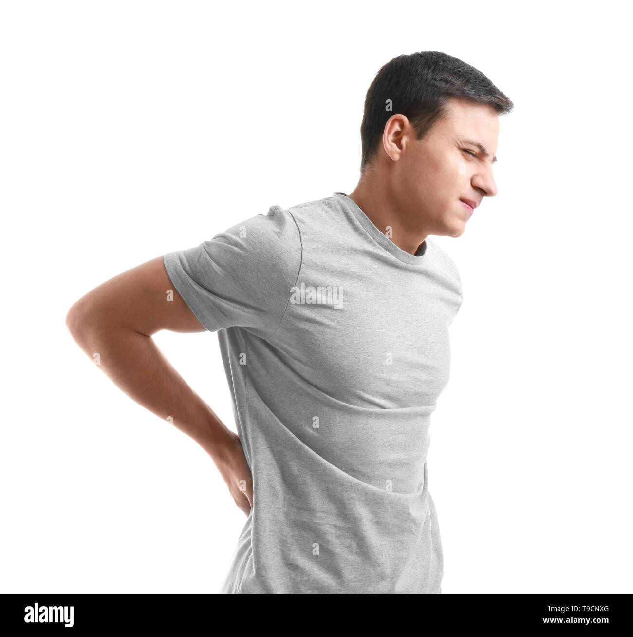 Young man suffering from back pain on white background Stock Photo - Alamy