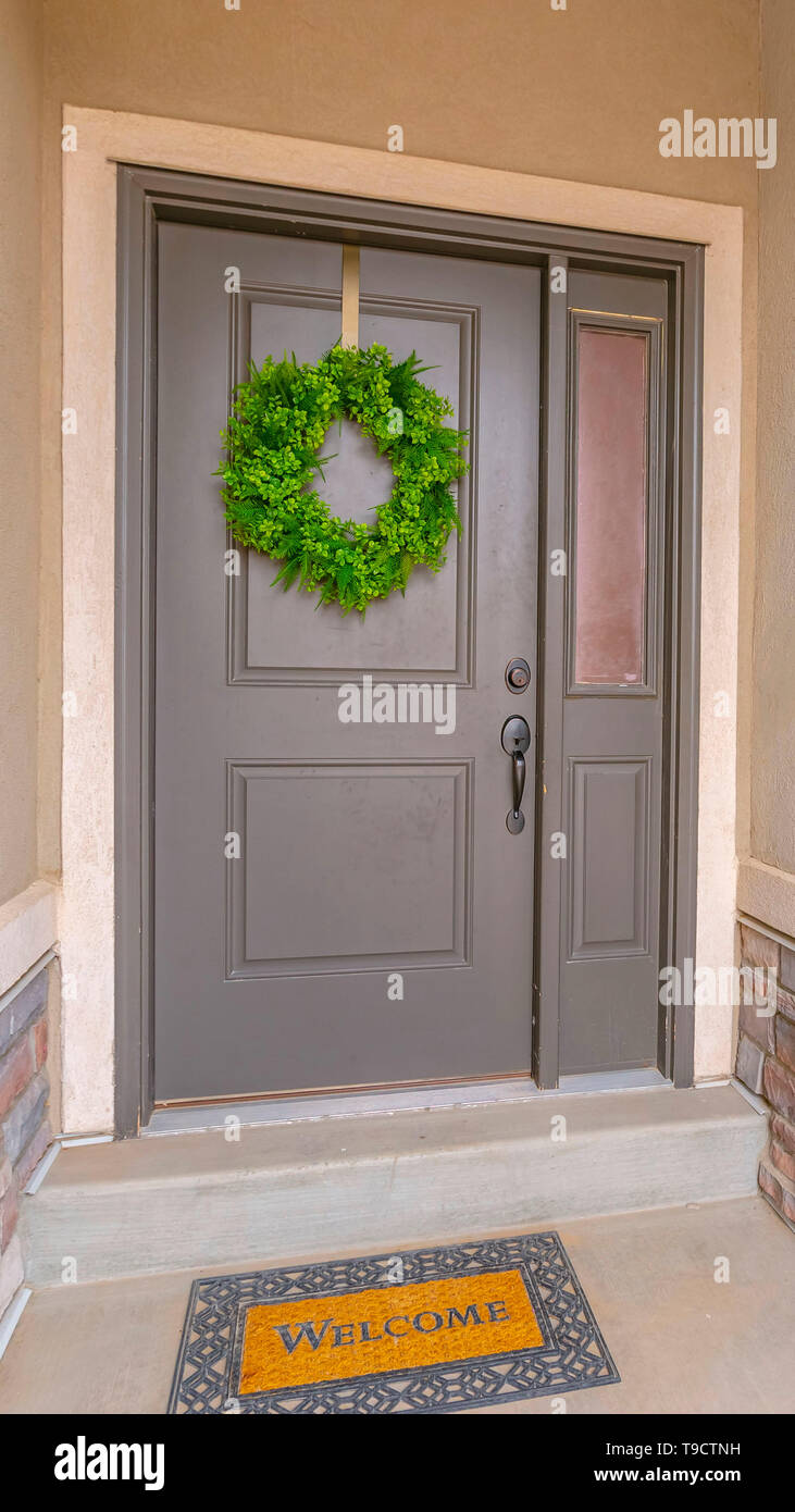 Vertical Gray Front Door Of A Home With A Simple Green Wreath And