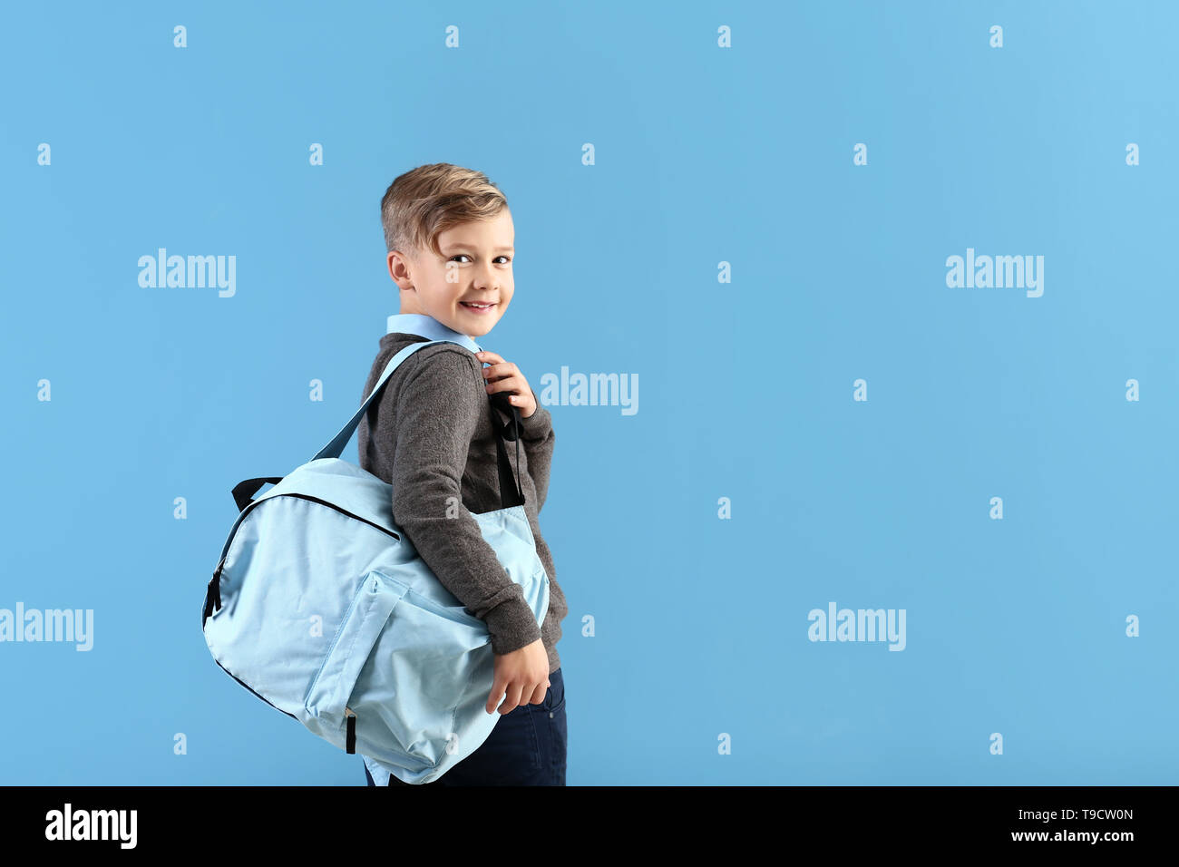 Cute little schoolboy with backpack on color background Stock Photo - Alamy