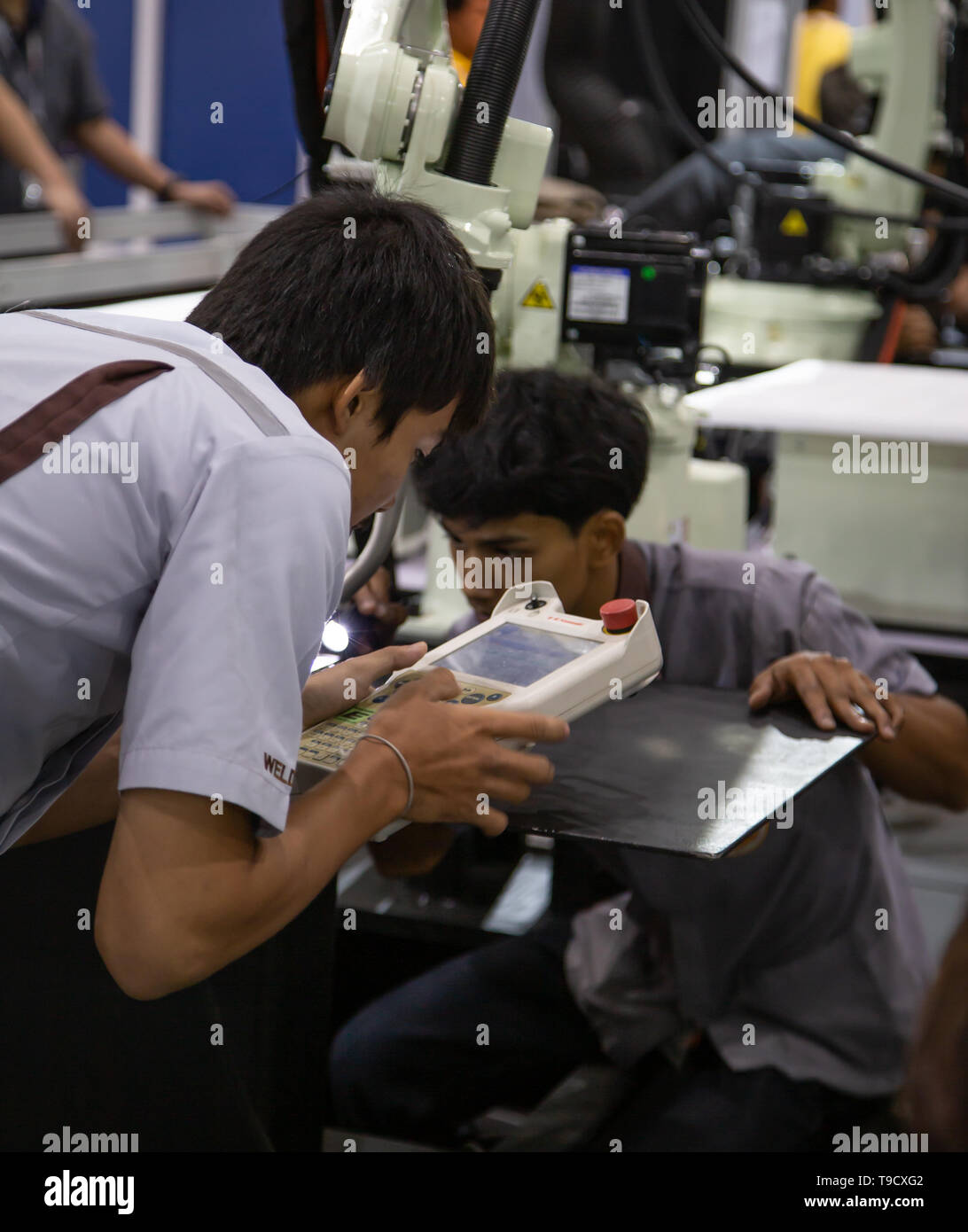Bangkok, Thailand - May 10, 2019: Industrial technician operating robotic welding arm in Intermach 2019 Stock Photo