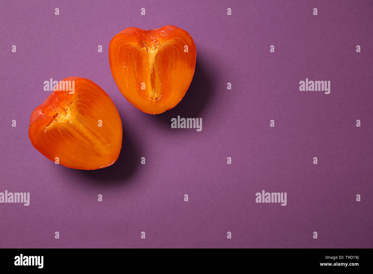 Halves of ripe persimmon on color background Stock Photo - Alamy
