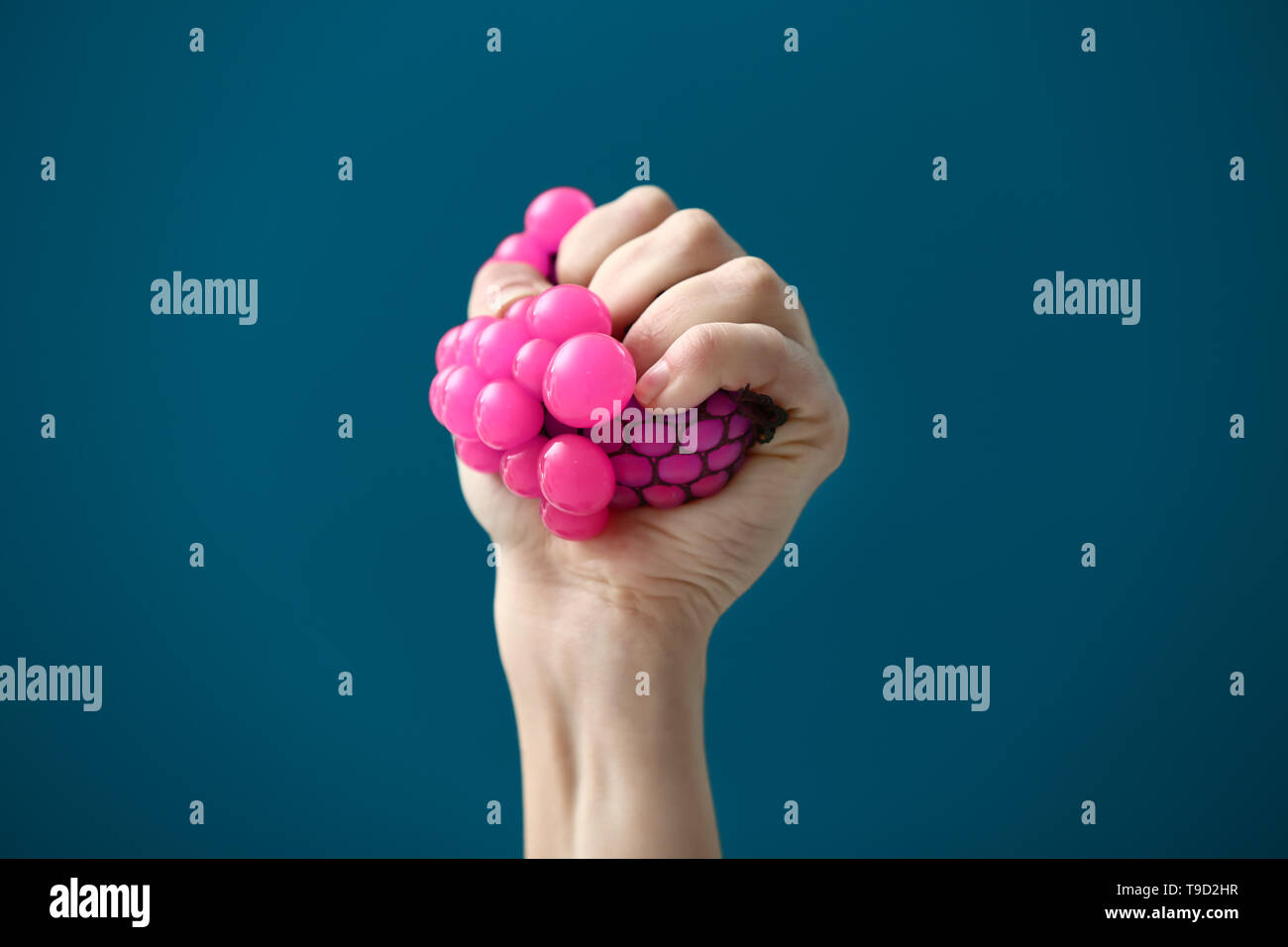 Female hand squeezing stress ball on color background Stock Photo Alamy