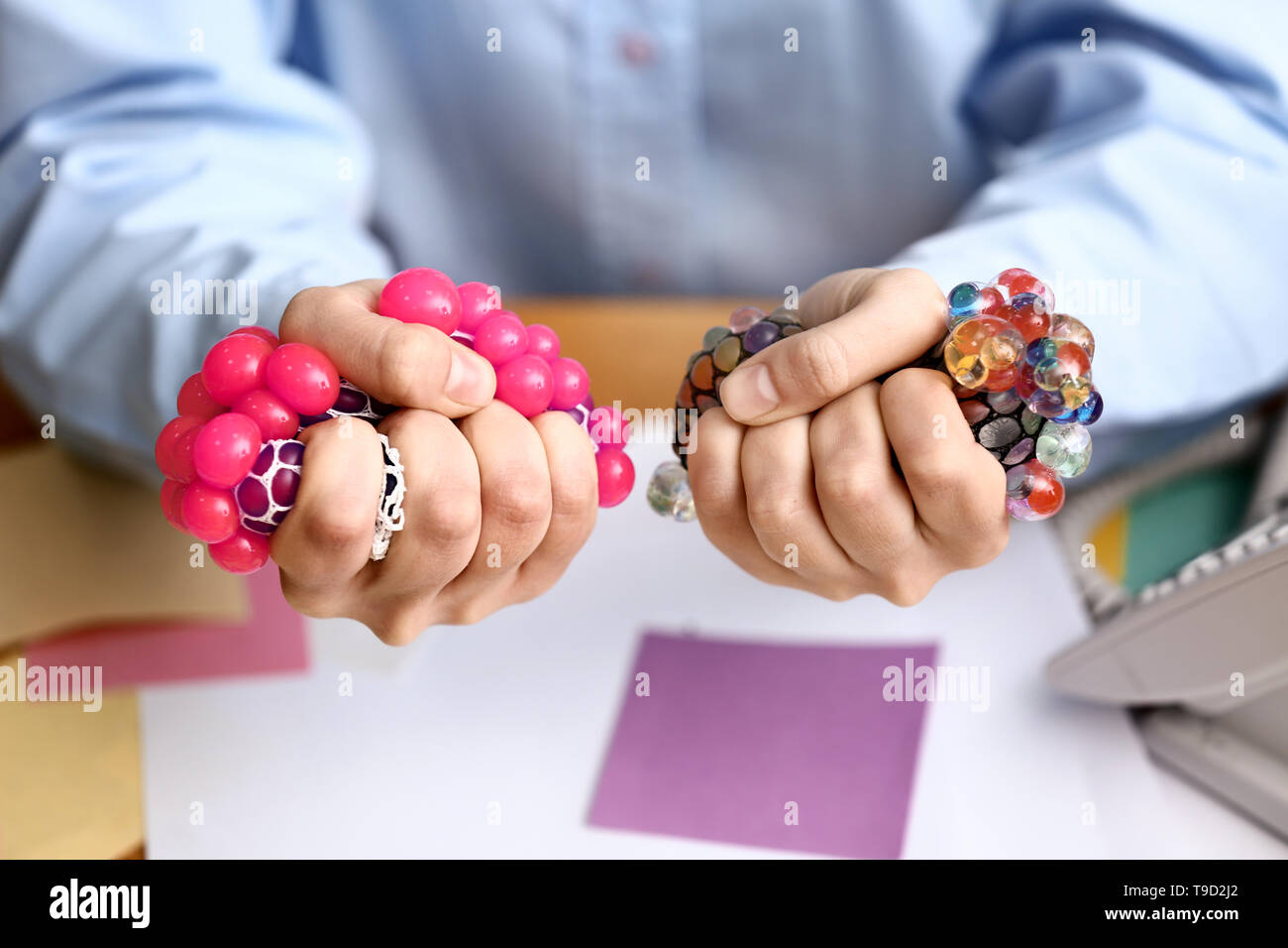 Woman squeezing stress balls in office, closeup Stock Photo - Alamy
