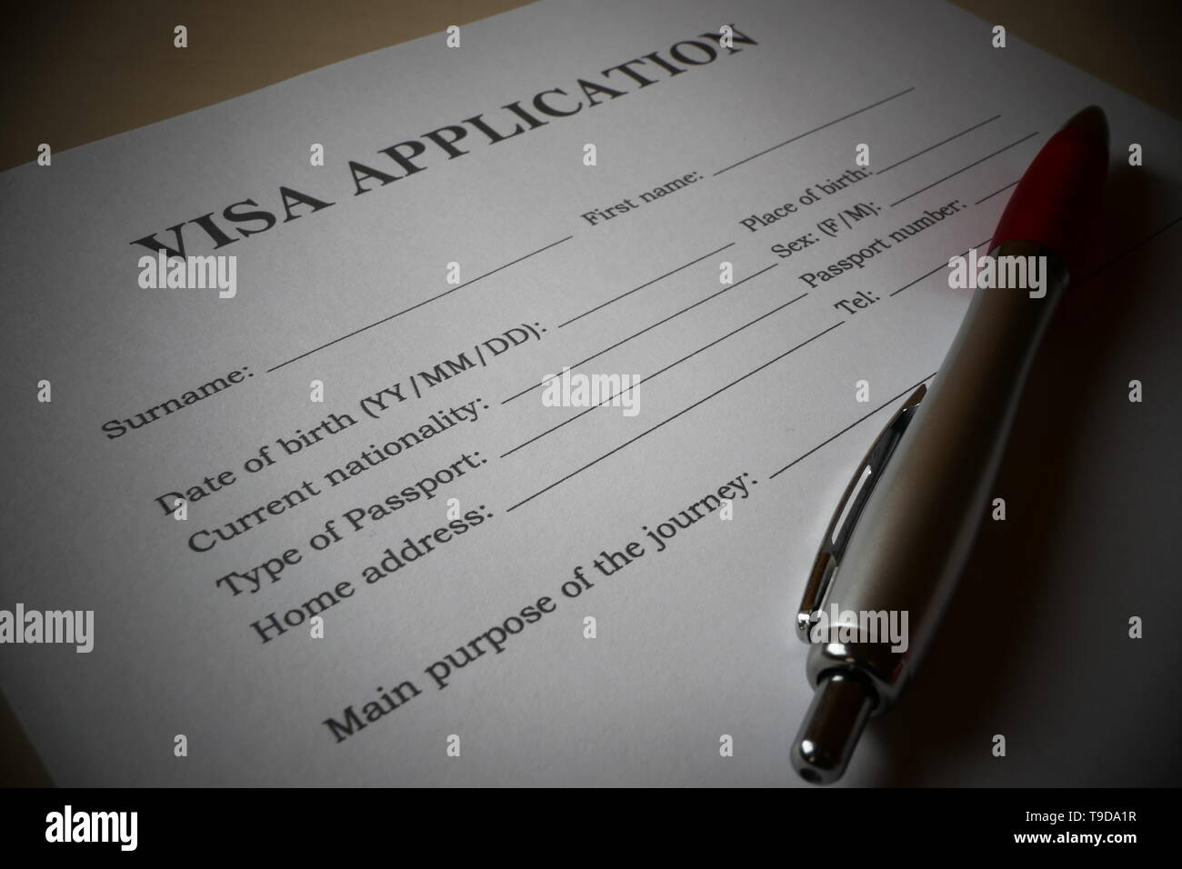 Visa application form with a pen for filling out. Document For applying to enter in a foreign country. Stock Photo