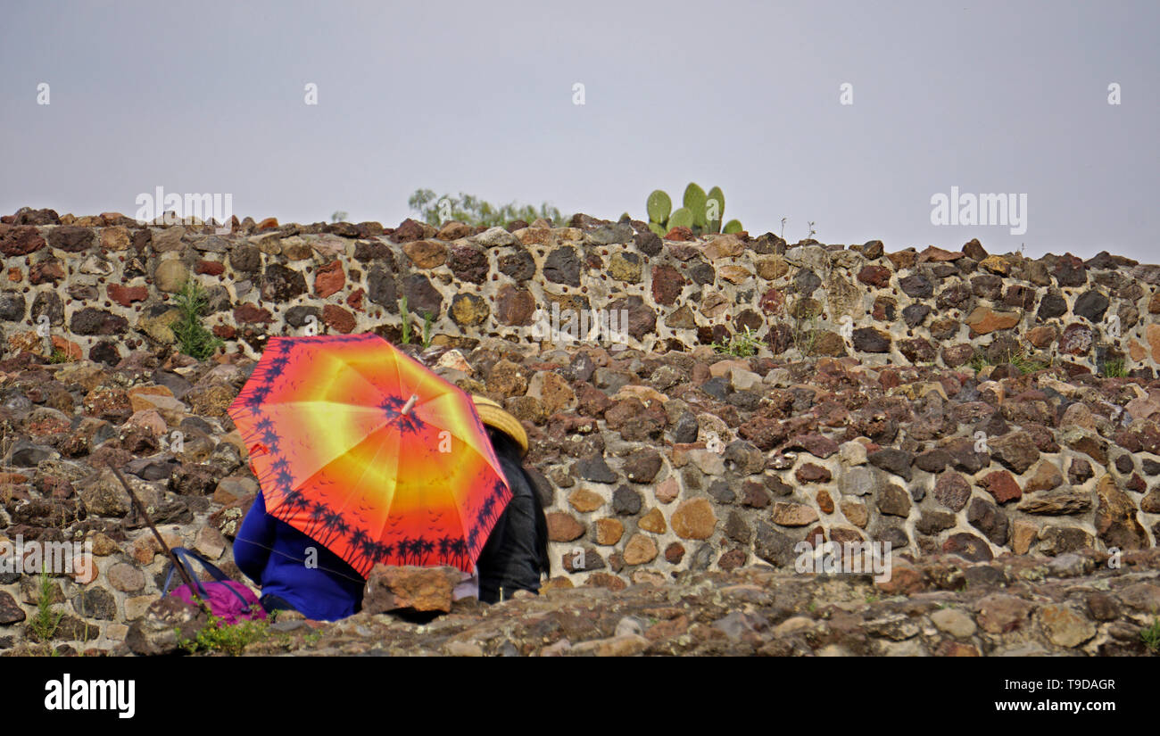 Colorful umbrella against an ancient wall.  Teotihuacan.  Ancient City.  Mexico. Stock Photo