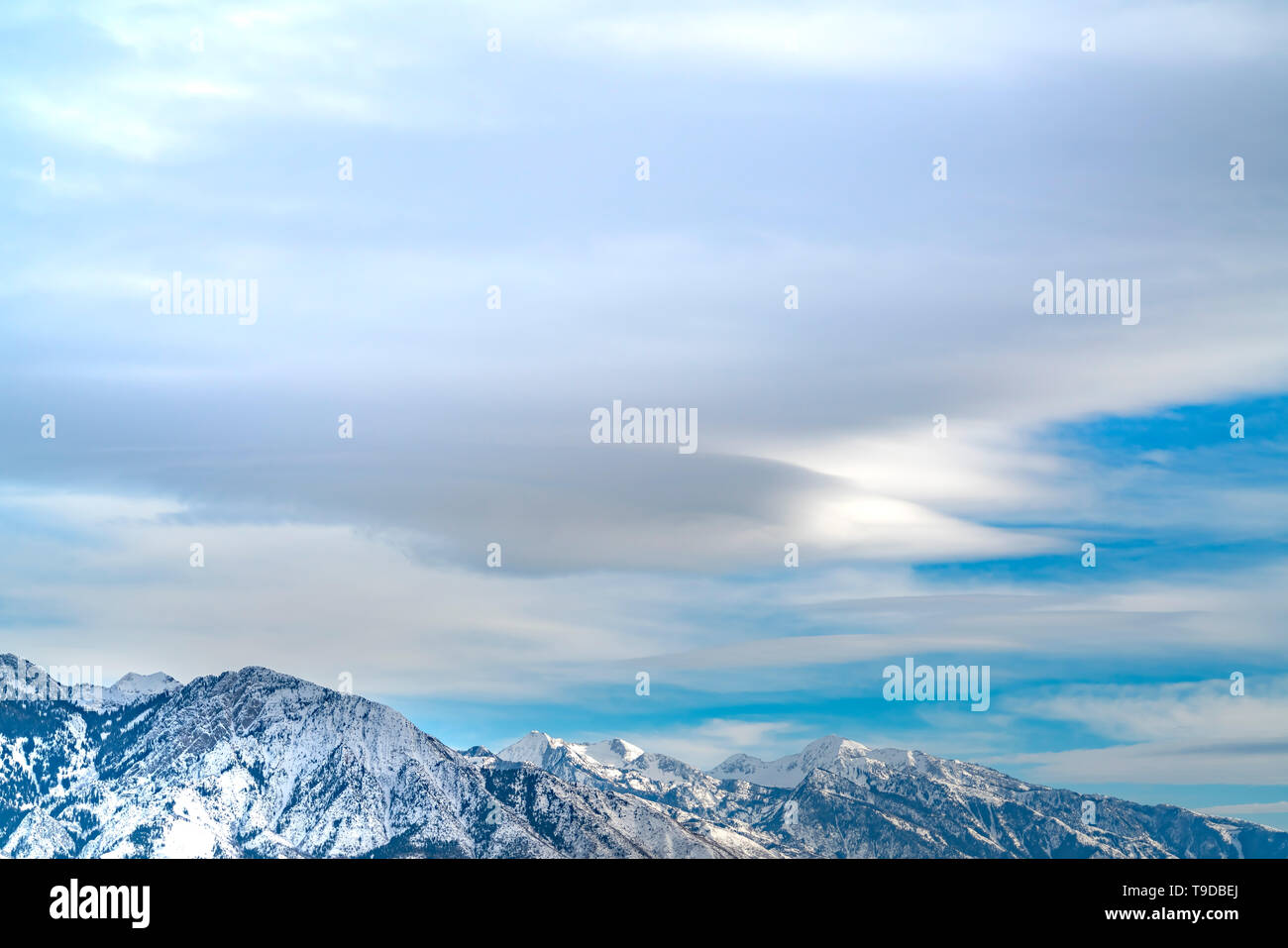 Striking mountain with rugged slopes under vast blue sky with clouds ...