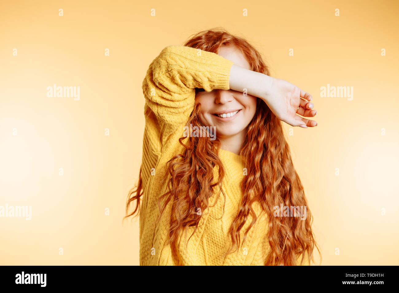 Nice Ginger Young Woman Closing Her Eyes With Hand Cute Smiling Wearing Bright Sweater Happy Curly Girl Hiding Face With Hand On Orange Background Wi Stock Photo Alamy