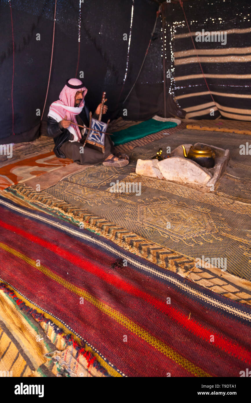 Beduino en la jaima tocando el instrumento musical Al Rababah, Wadi Rum, Jordania, Oriente Medio Stock Photo
