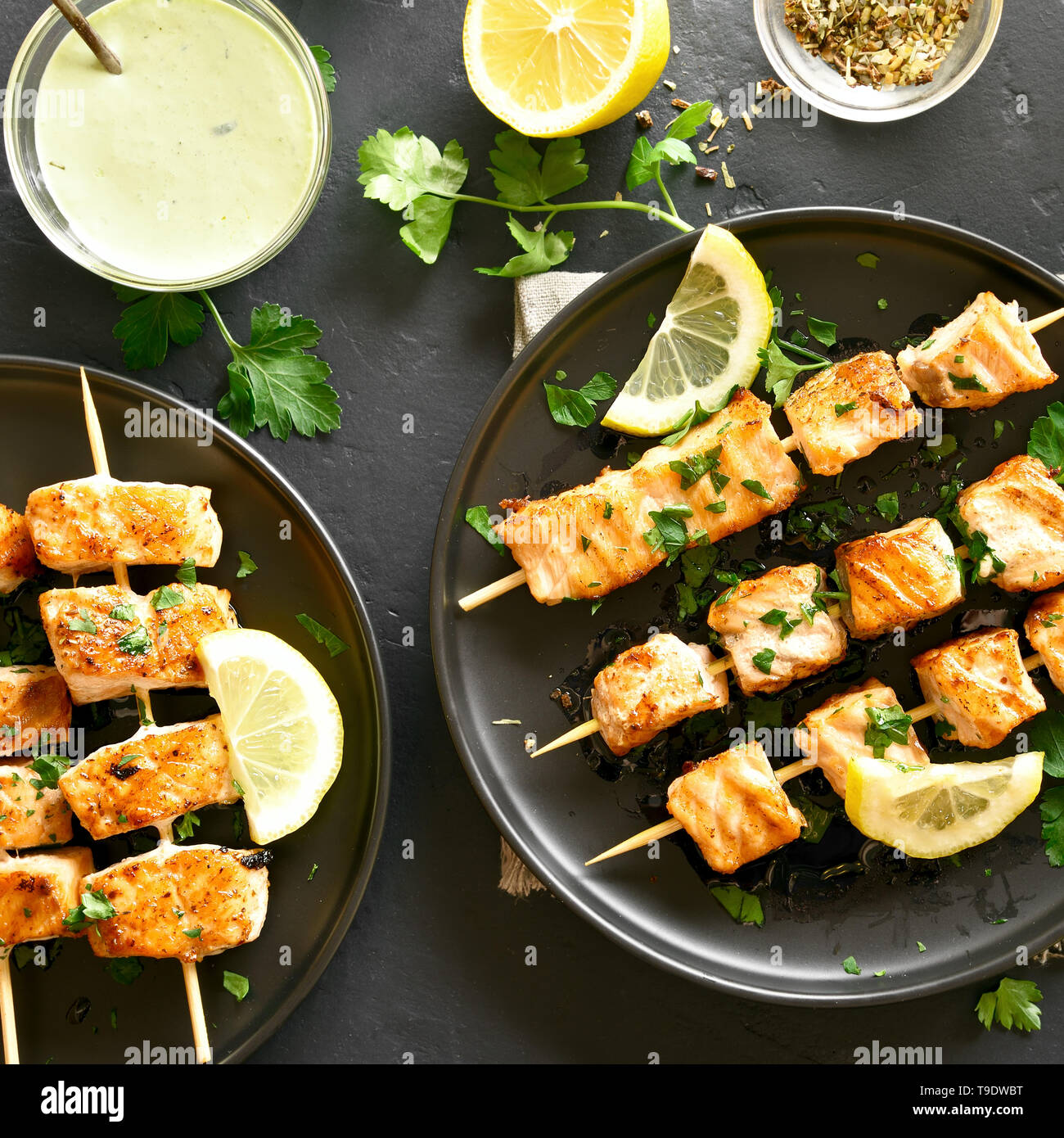 Barbecue salmon skewers on black stone background. Tasty grilled salmon