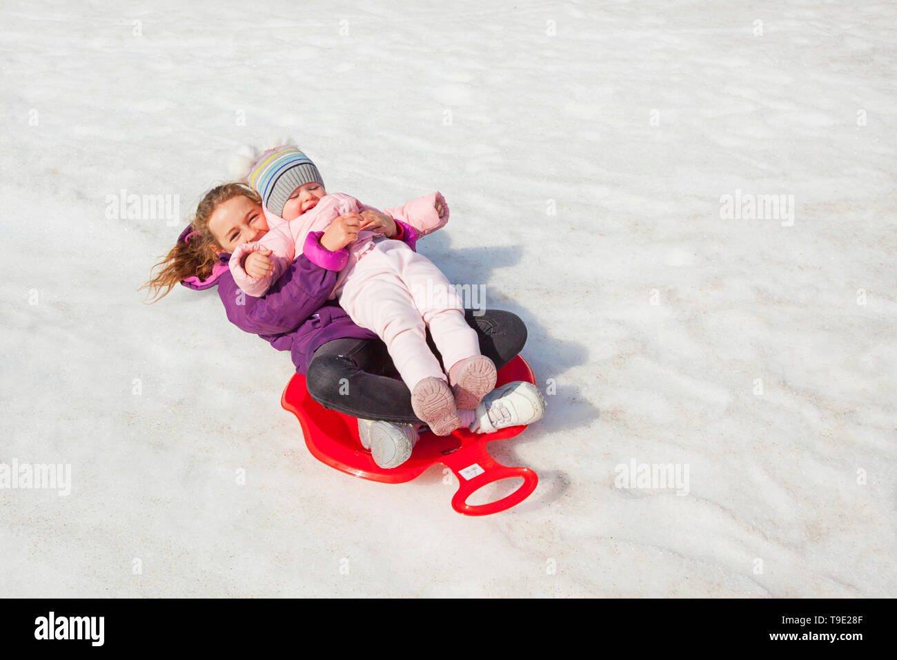 Two girls sledding, Kranjska Gora, Slovenia Stock Photo