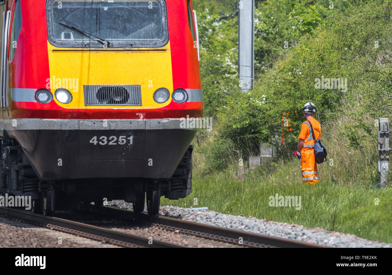 Network rail engineers with bright orange PPE clothing on the East Coast mainline track. Stock Photo