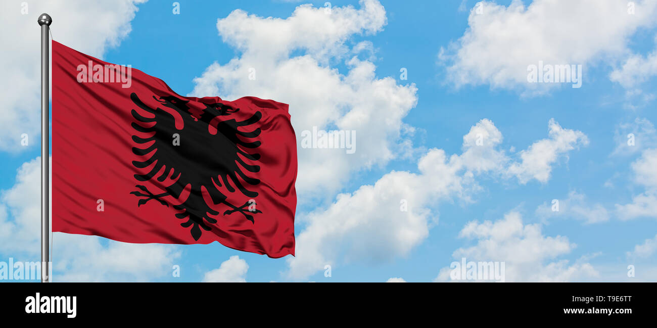 Albania flag waving in the wind against white cloudy blue sky ...