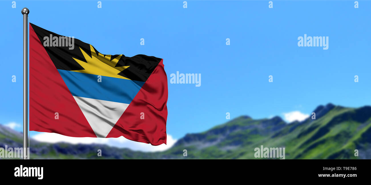 Antigua and Barbuda flag waving in the blue sky with green fields at