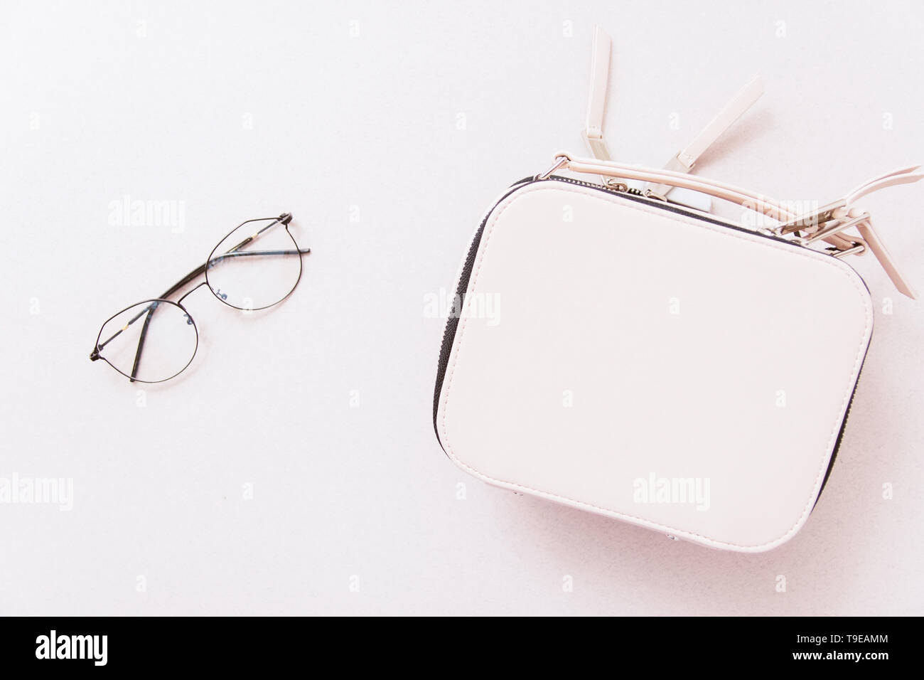 White bag and image glasses on a beige background. The concept of feminine style. Copyspace and top view Stock Photo