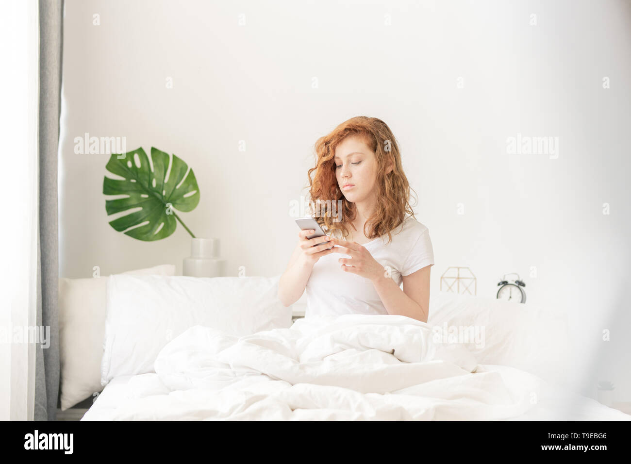 Texting in bed Stock Photo