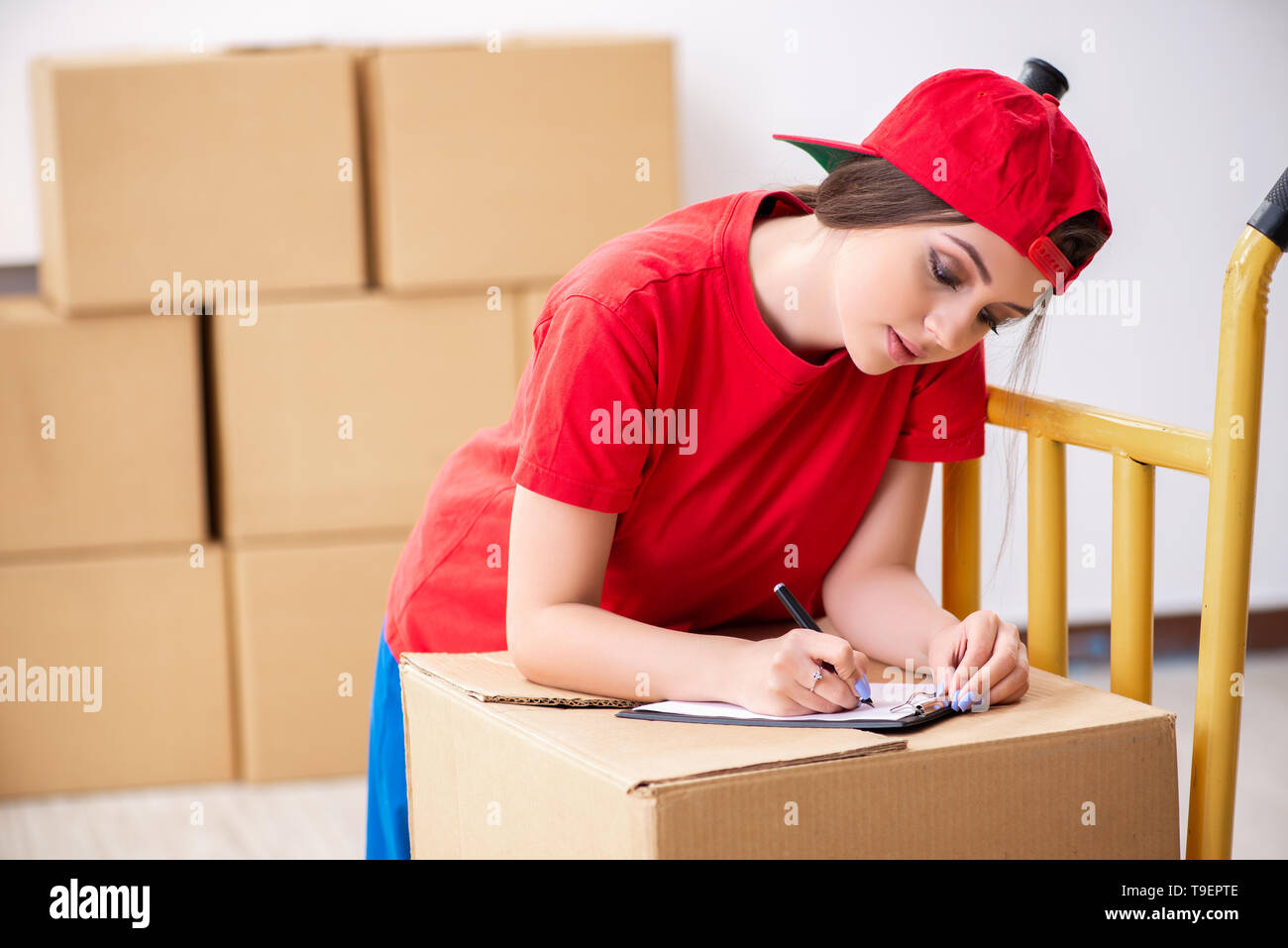 Young female professional mover doing home relocation Stock Photo