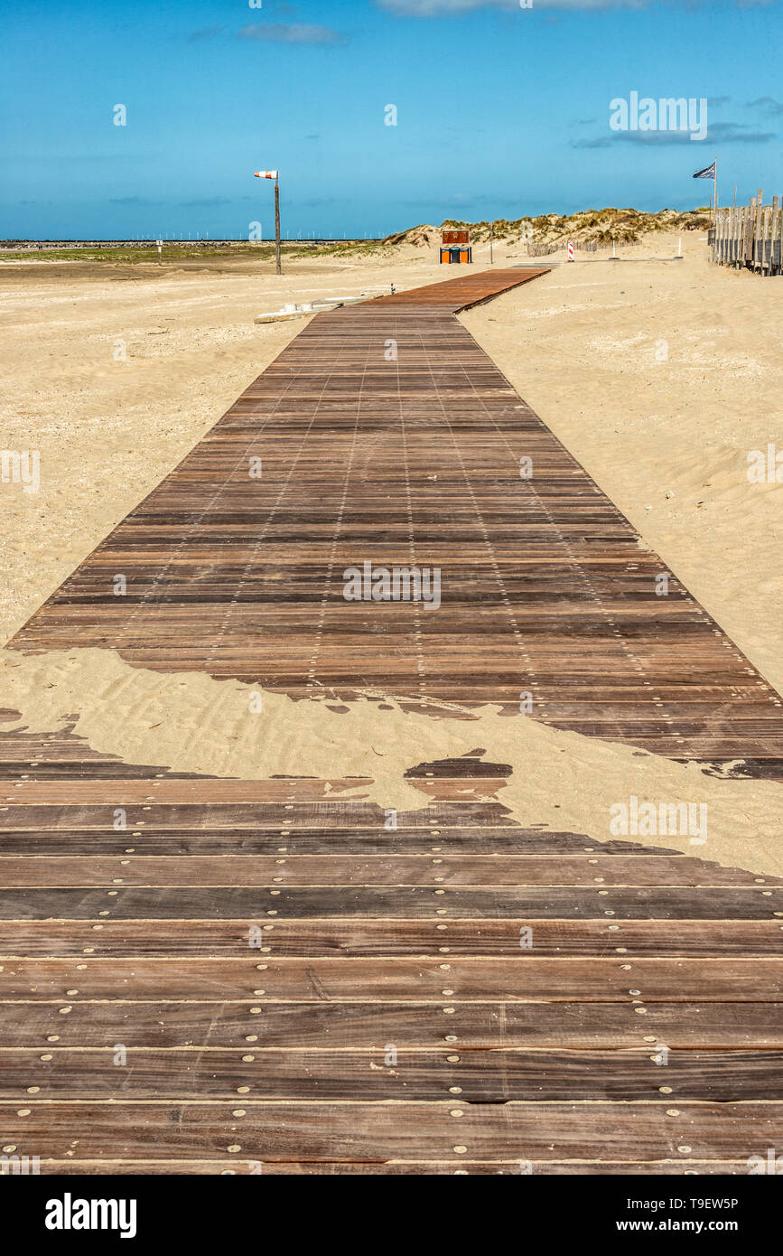wooden gangways on the beach with a dune area in the distance Stock Photo
