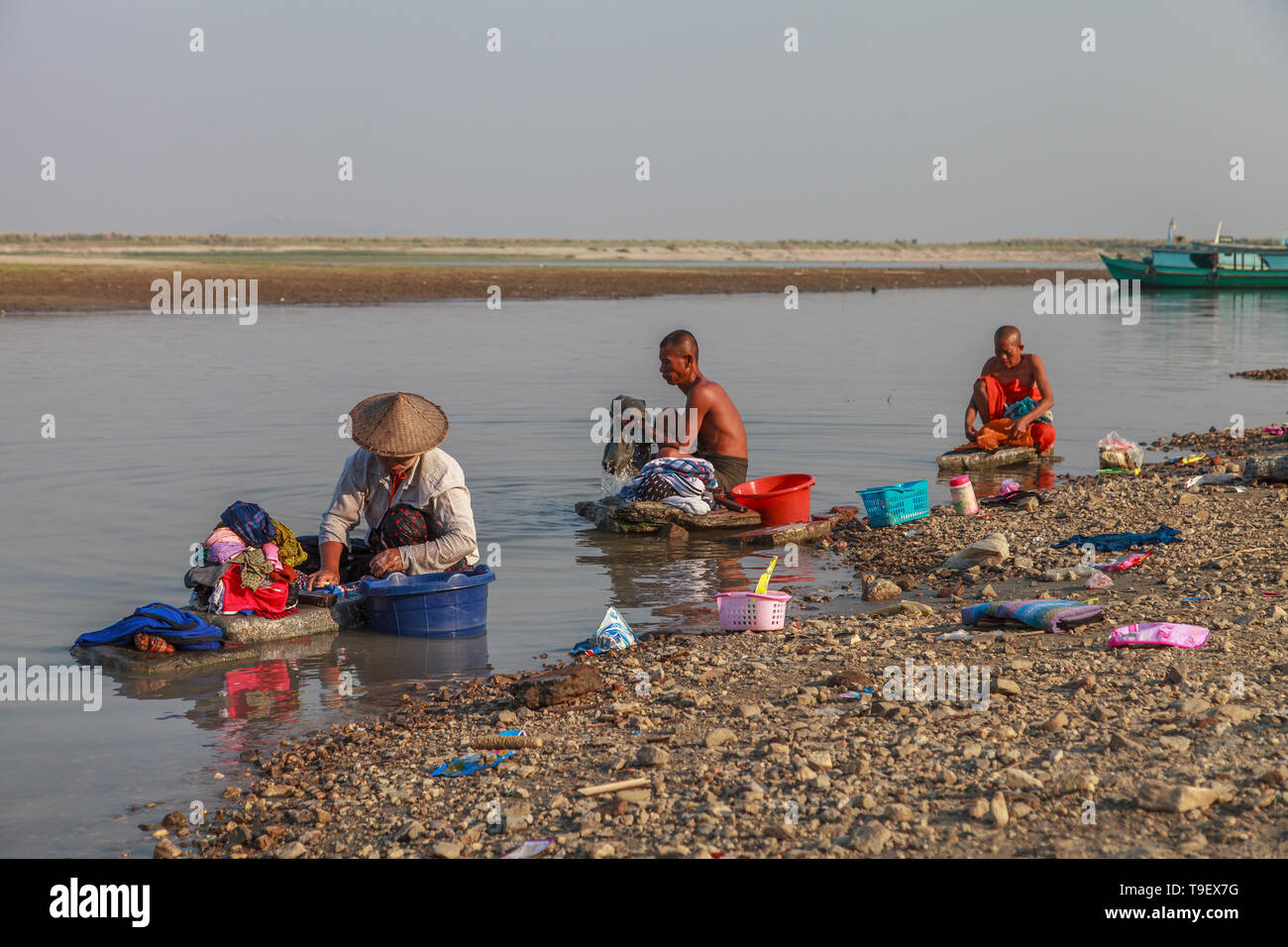 Men washing clothes along the river Irrawaddy Stock Photo