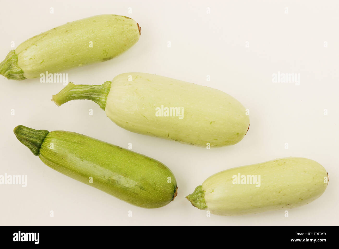 Courgettes arranged on a white background in random order, top view Stock Photo