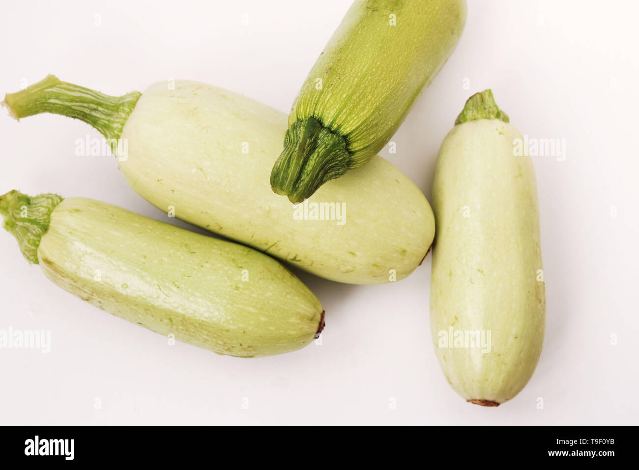 Courgettes arranged on a white background in random order, top view Stock Photo