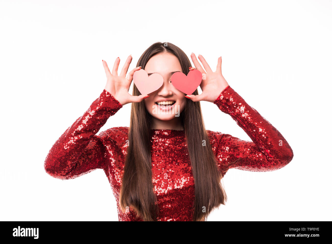 Attractive young asian woman holding red love hearts over eyes on white ...