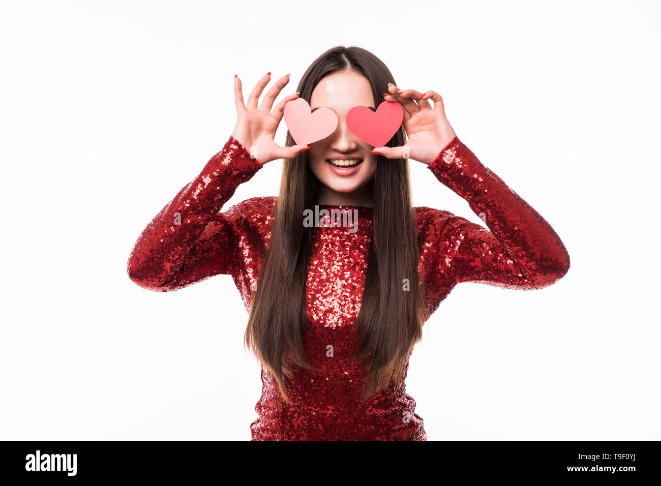 Attractive young asian woman holding red love hearts over eyes on white ...
