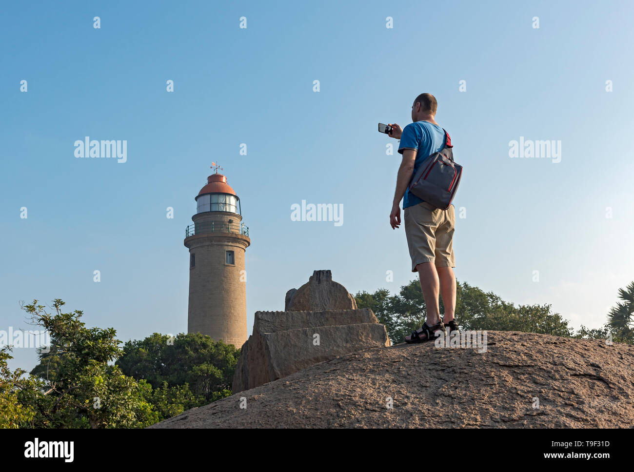 Tourist takes photos of Mahabalipuram lighthouse, Mamallapuram, India Stock Photo
