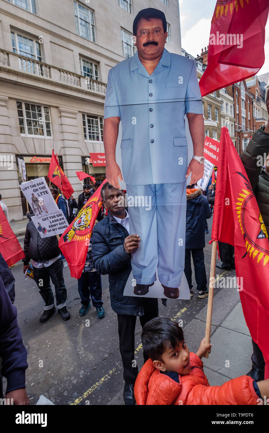 London, UK. 18th May 2019. A man holds a large figure of Velupillai Prabhakaran (1954-2009) the founder and leader of the LTTE before the march by several thousand Tamils through London on Mullivaikkal Remembrance Day in memory of those killed by Sri Lanka’s genocidal war against the Tamils, which ended ten years ago. They call for a political solution which gives Tamils back control of their homeland of Tamil Eelam, and for an end to the ban on the Tamil Tigers. Public commemorations of the many thousands of war dead are forbidden in Sri Lanka. Peter Marshall/Alamy Live News Stock Photo