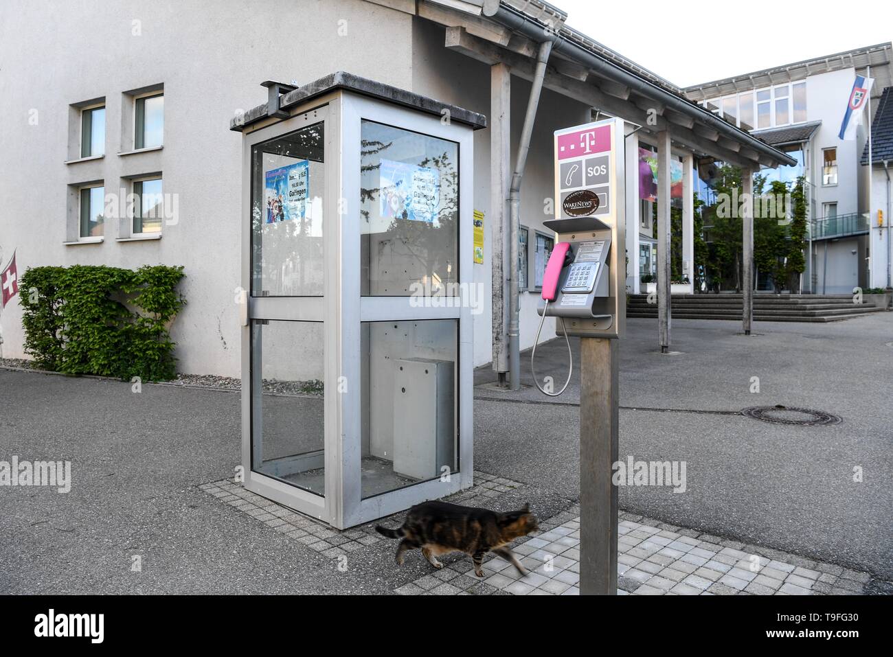 13 May 2019, Baden-Wuerttemberg, Büsingen am Hochrhein: A telephone box  from Switzerland (l) which has been taken out of service is located in the  centre of town next to a public telephone