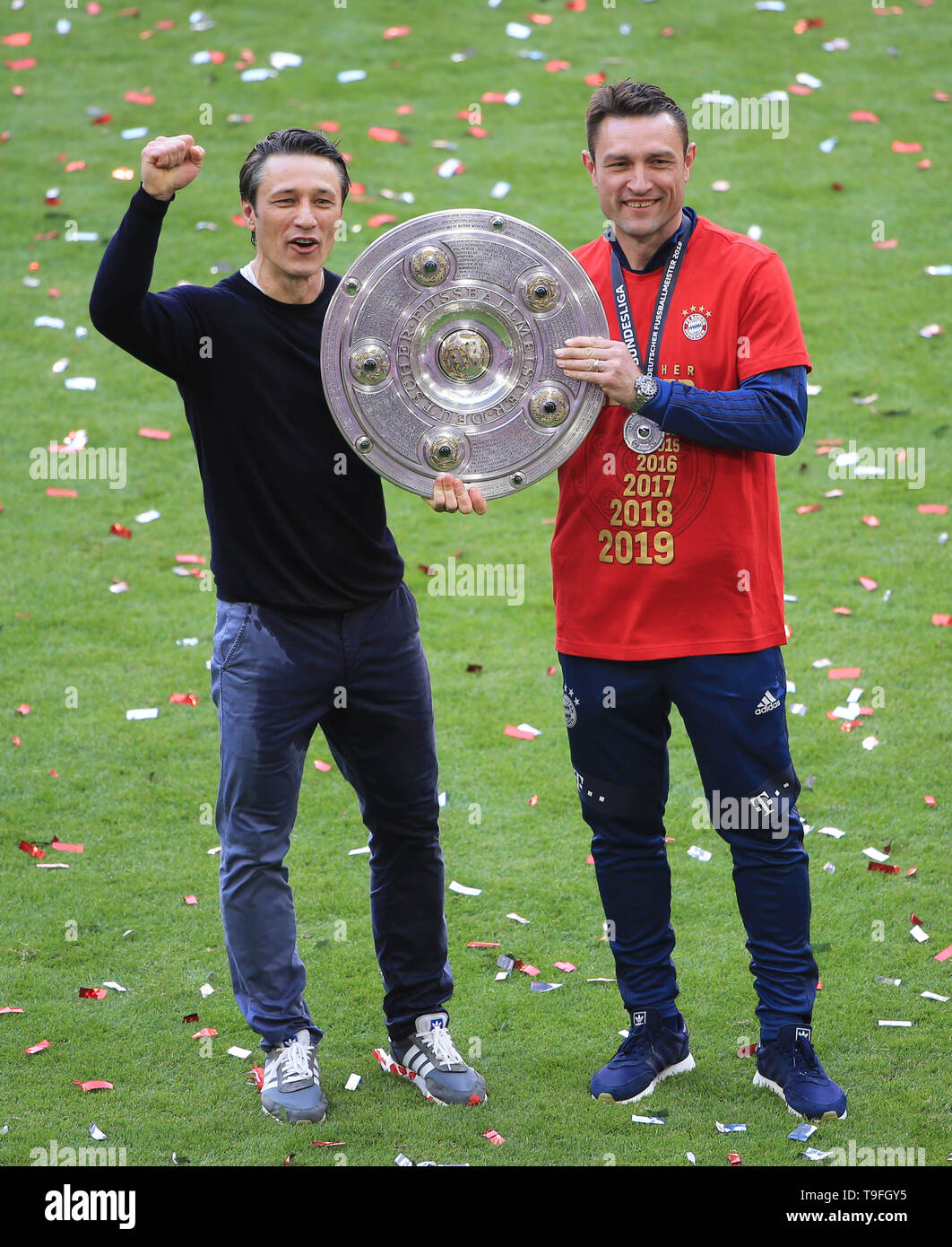 Munich, Germany. 18th May, 2019. Bayern Munich's head coach Niko Kovac (L)  and his brother and assistant coach Robert Kovac pose for photos with the  trophy during the awarding ceremony after a
