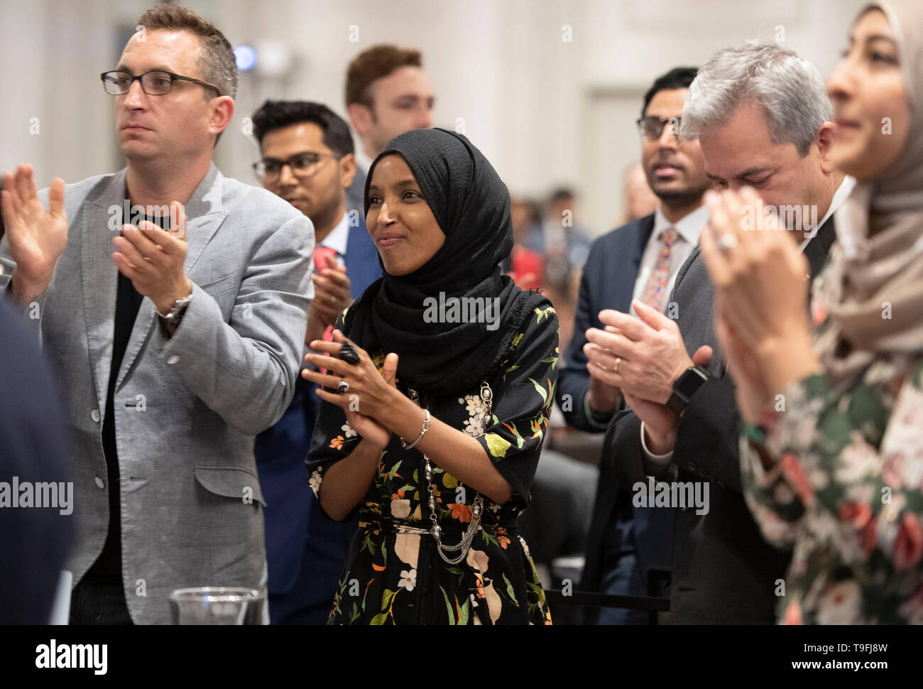 Congresswoman Ilhan Omar of Minnesota's 5th Congressional District stands and applauds a speaker at the annual city-wide iftar dinner in Austin, Texas, in honor of the 14th day of Ramadan.Omar was the event's featured speaker. Stock Photo