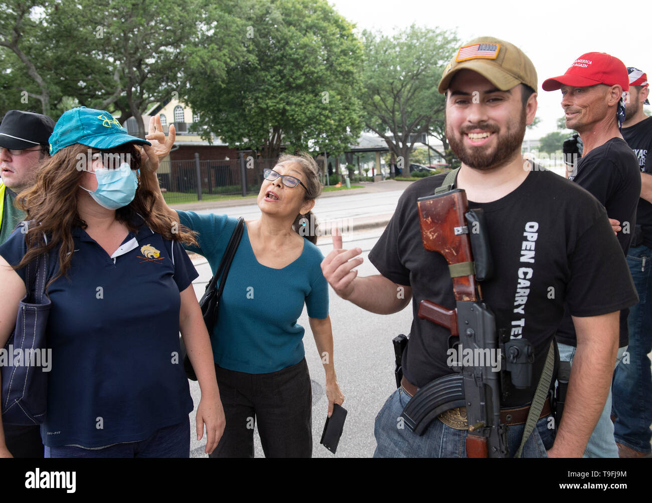 A supporter of Ilhan Omar (center) confronts anti-Muslim protesters, some opening carrying guns legally, outside an Austin, Texas, hotel where the controversial Muslim Congresswoman spoke at a city-wide iftar dinner. Stock Photo