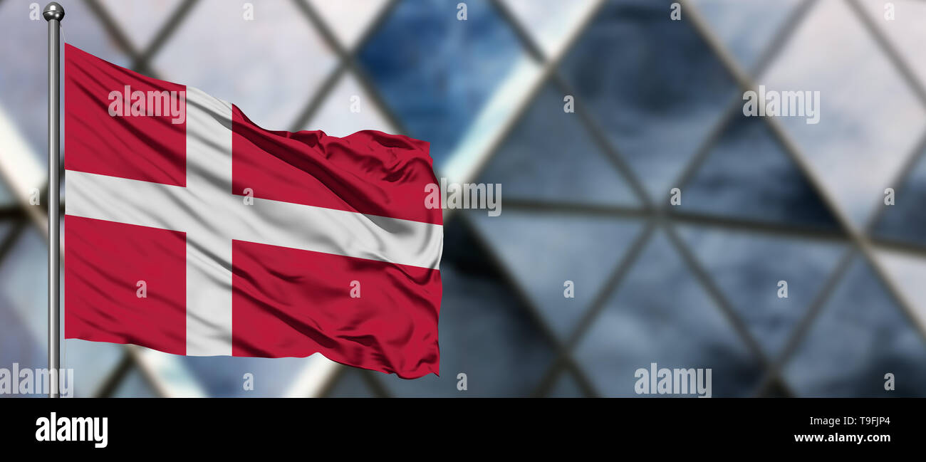 Denmark flag waving in the wind against blurred modern building. Business concept. National cooperation theme. Stock Photo