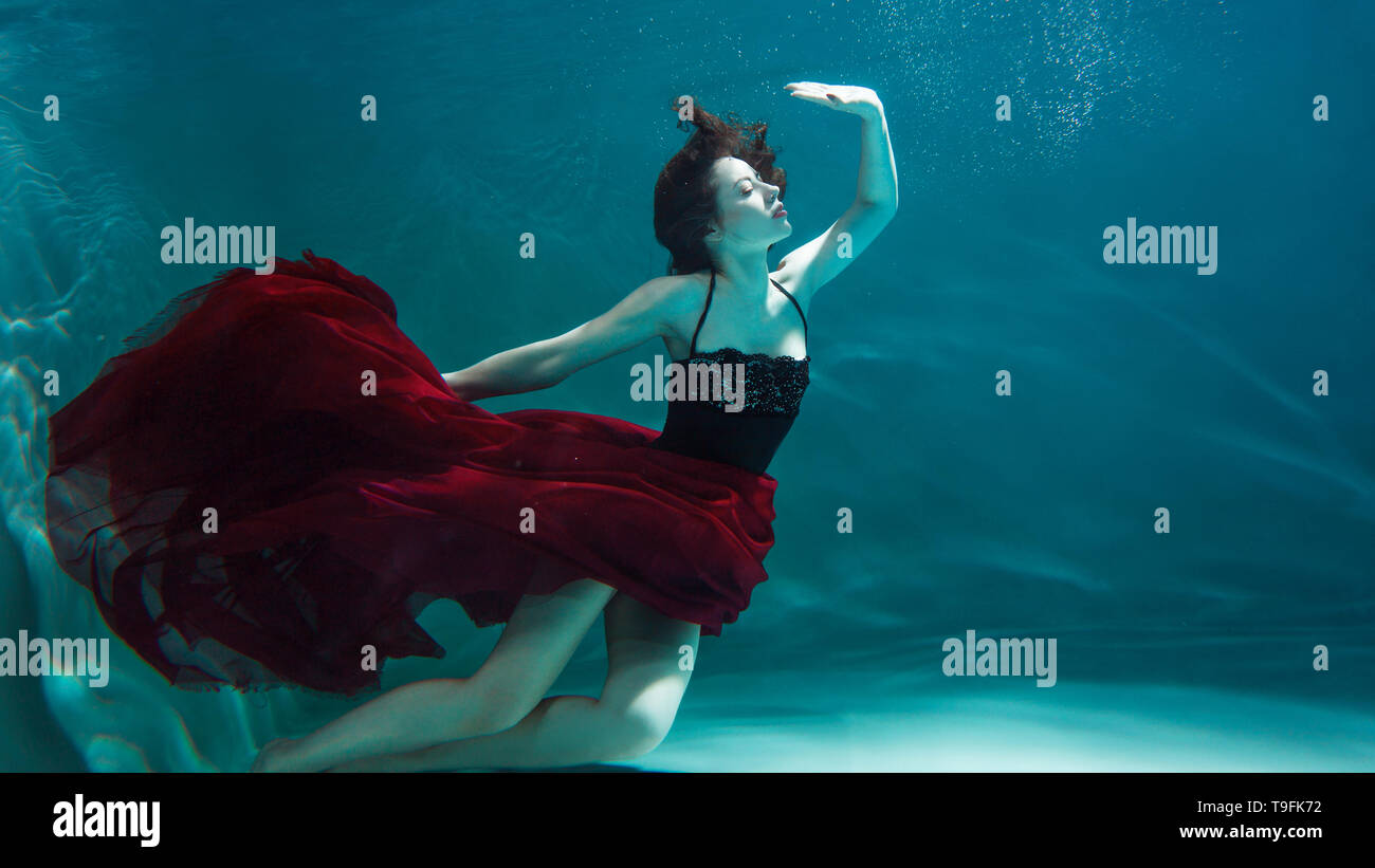 Beautiful girl in a red dress swims under water. amazing Underwater beauty  photo Stock Photo - Alamy