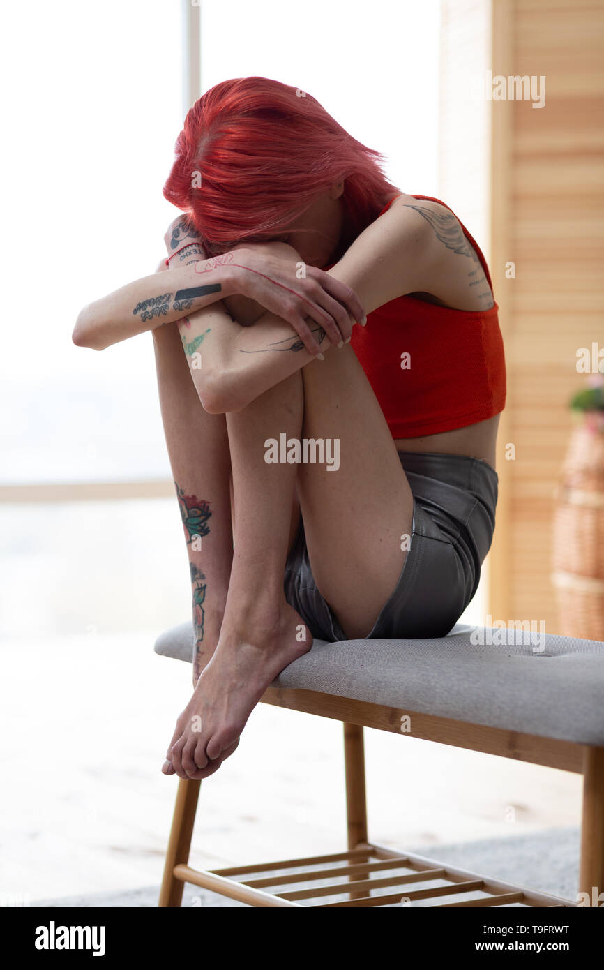 Anorexic woman hugging her knees while feeling awful Stock Photo